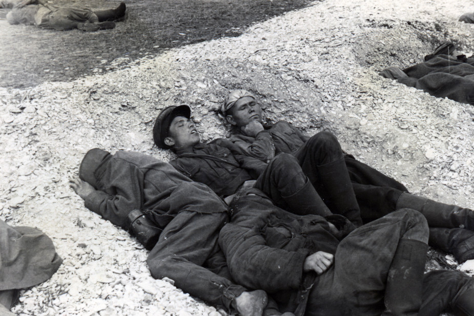 На снимке пленные, спящие под открытым небом, спасаются от холода в выкопанных углублениях, группируясь по несколько человек