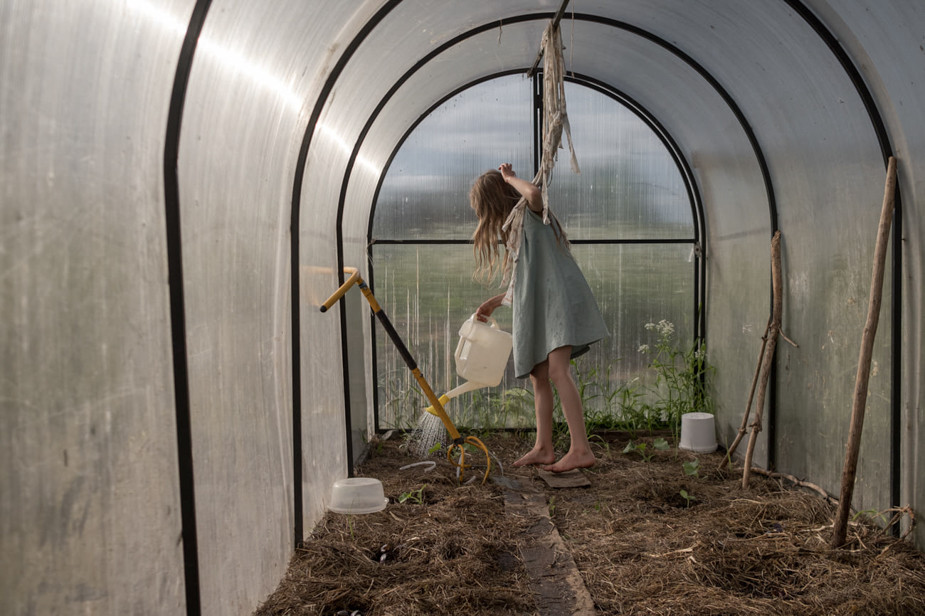 Ася поливает всходы в теплице